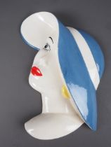An Art Deco Beswick wall plaque formed as a woman with blue hat, 11 1/4" high