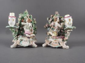 A pair of 18th century Chelsea style candlesticks decorated putti, 8" high