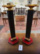 A pair of painted pine tabletop candlesticks in gold black and red, raised over hexagonal bases,