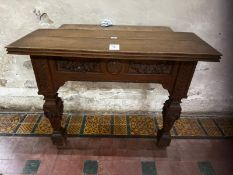 An interesting 19th century oak console table having inset frieze to plank top, carved panels below,