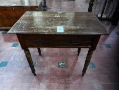 An Edwardian mahogany frieze table raised over ring turned legs having single drawer with twin drop