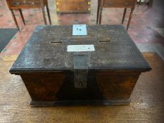 A 19th century lidded oak hinged-top box previously used as a votive candle payment repository,