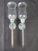 A pair of candle wall sconces with glass shades