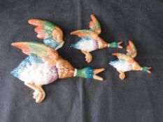 A set of three flying duck wall plaques by Beswick, largest a/f, middle with naive repair.