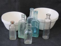 A pair of graduated Mason Cash mixing bowls together with a quantity of vintage glass bottles.