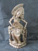 A carved wooden Indo-Asian deity figure.