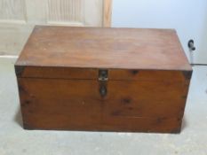 A pine blanket box or trunk having metal end handles and corner bracing, measuring 67 x 39 x 32cm.