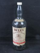An oversized glass Bells Whisky bottle.