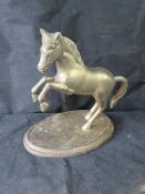 A large brass horse, weighted base.