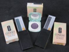 Three Clinique makeup compacts in original packaging.