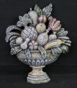 A carved and painted wooden decorative panel in the form of a fruit bowl.