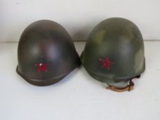 Two Russian helmets, one with original liner, the other with a German replacement liner.