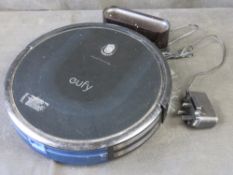 A Eufy RoboVac 115 Max with charger.