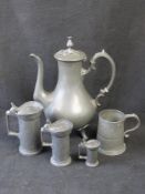 A set of three graduated pewter measures with lids,