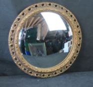 A mid 20th century convex mirror in gilt plaster frame, no label possibly Ansonia.