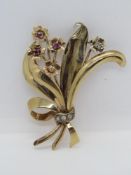 A diamond and ruby set floral brooch, yellow metal no apparent hallmarks,7.4g.