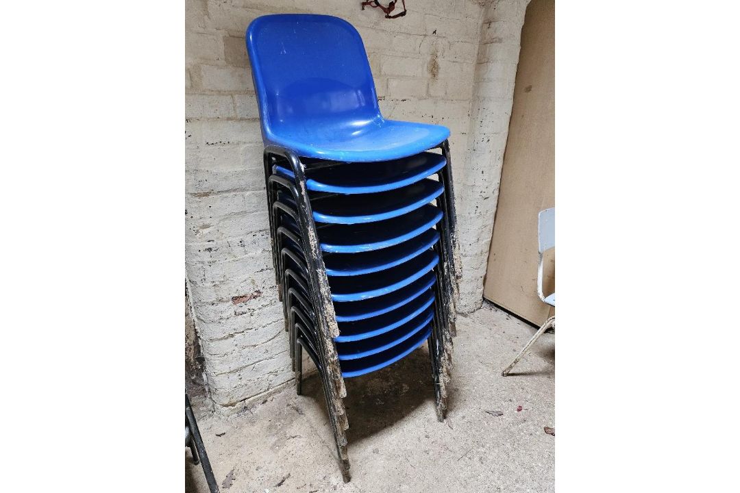 Ten blue plastic stacking chairs.