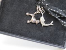 Links of London; two silver charms having Links hallmark upon in the form of a dolphin and a poodle.