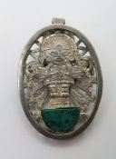 A Mexican silver brooch or pendant in Aztec style with green stone upon.