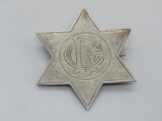 A hallmarked silver brooch in the form of a star with monogram to centre, approx 4.2cm wide.
