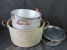 A quantity of steel kitchen pans and platters.