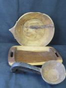 A vintage African bowl and ladle, each with naive repair, and a contemporary wooden serving platter.