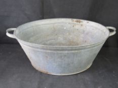 A galvanized steel basin, 66.5cm wide including handles.