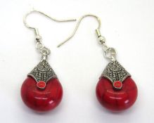A pair of red stone drop earrings.