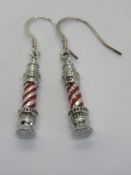 A pair of lighthouse themed earrings, with red enamel design.