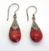 A pair of small red stone drop earrings.