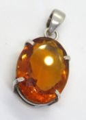 A large faceted orange stone pendant in silver frame, stamped 925.