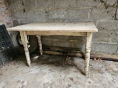 A pine table with painted legs.