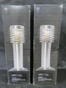 A pair of brushed stainless steel bollard garden path or driveway lights.