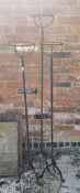 A set of three graduated wrought iron tall candle stands, 129 - 148cm tall.