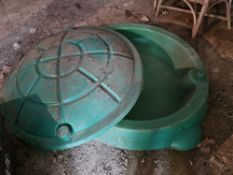 A plastic sand pit with cover.