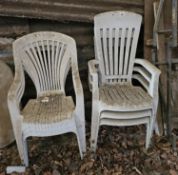 A quantity of white plastic garden chairs..