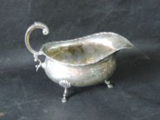 A hallmarked silver sauce boat raised over three feet and standing 10cm high,