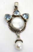 A hallmarked silver pendant having mother of pearl and blue stone design.