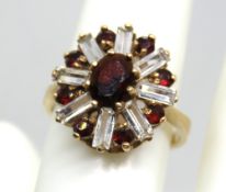 A vintage 9ct gold cocktail ring having baguette cut white stones in a starburst cluster around a