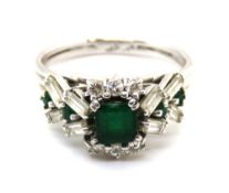 An elegant emerald and diamond cluster ring having central square cut emerald measuring approx 5 x