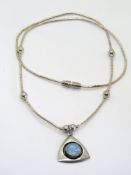 A silver bead necklace and opal pendant in the Native American style.
