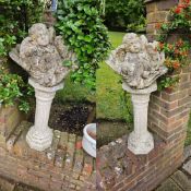 A pair of sleeping putti raised over column bases, 97cm high.