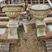 A good pair of stoneware garden urns raised over square shaped bases, 82cm high, 50cm wide.