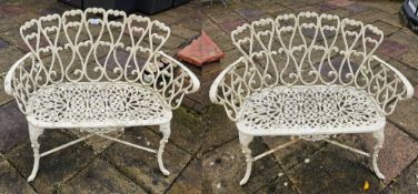 A fine pair of cast metal two-seater cream painted garden benches, each 95cm wide.