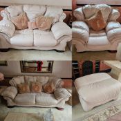 A pink leather suite comprising three-seater sofa, two-seater and single armchair with footstool.