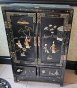 A Japanese lacquered two door cabinet with applied decoration, 61cm x 31cm x 92cm.
