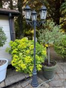 A contemporary garden lamppost with three sconce lights.