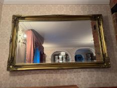 A contemporary gilded bevelled edge mirror measuring 130 x 76cm.