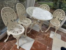 A cast aluminium garden table with four chairs, table 80cm dia.