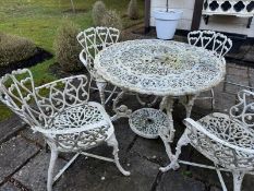 A circular cast metal table 92cm wide with four matching chairs.